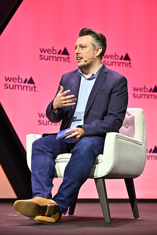David Walsh moderating a panel on stage at Web Summit.
